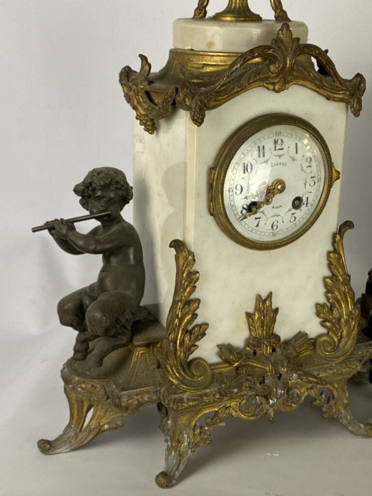 Pendule borne en marbre blanc, flanquée de deux satyres en bronze patiné, ornem…