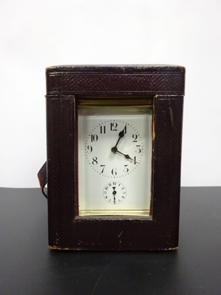 Pendule d'officier en bronze et verre biseauté, dans son coffret en cuir chiffr…
