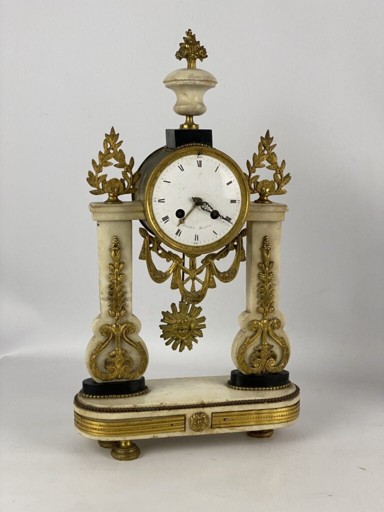 Pendule portique en marbre blanc et noir et bronze cisélé à décor de perles, fe…