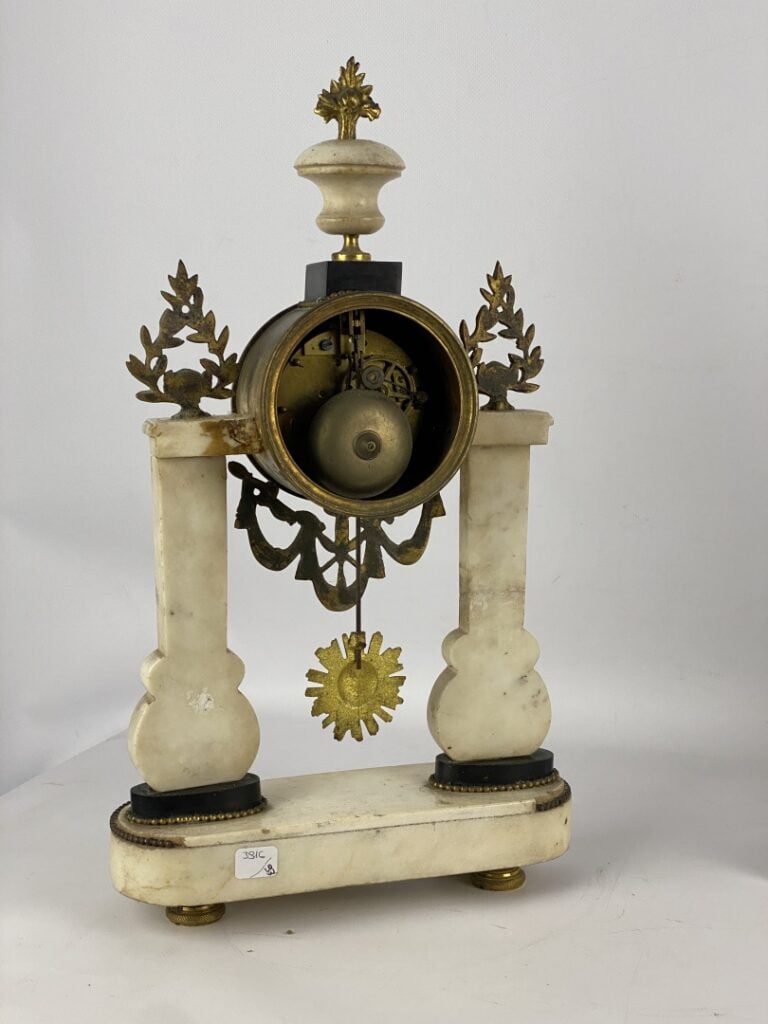 Pendule portique en marbre blanc et noir et bronze cisélé à décor de perles, fe…