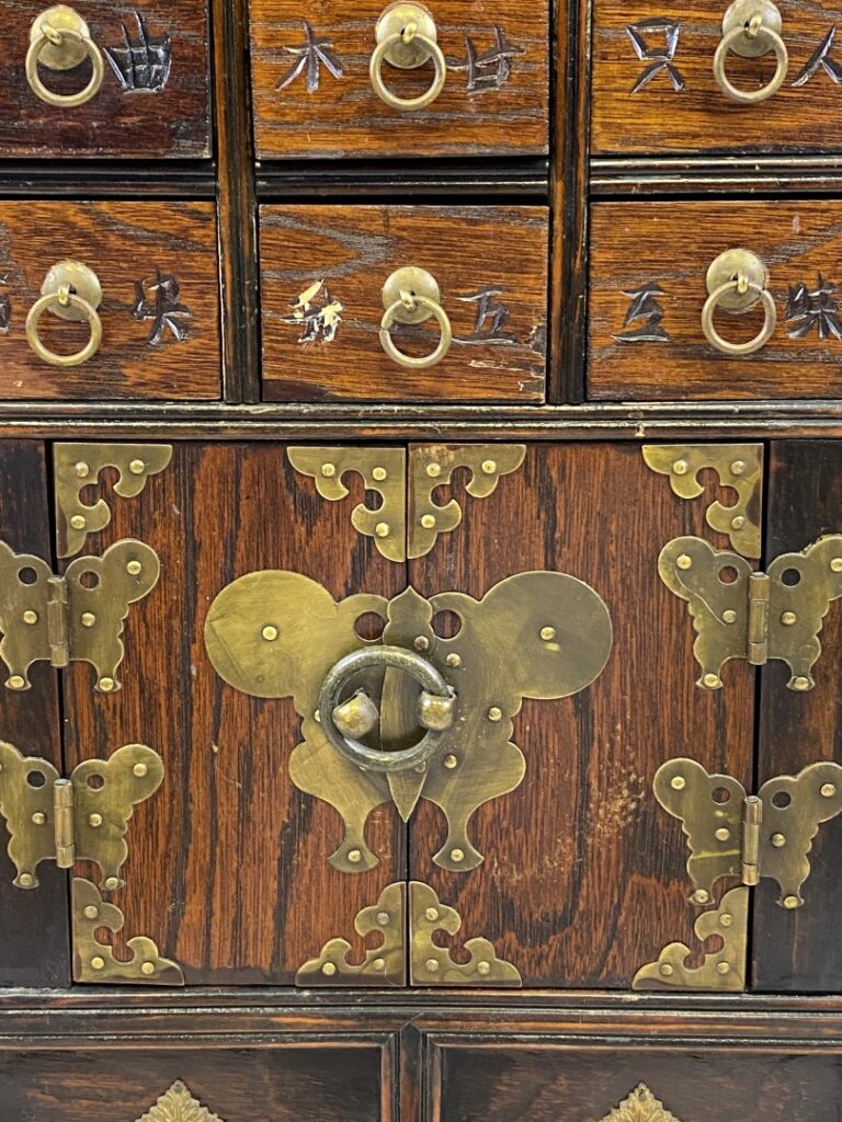 Petit meuble d'apothicaire à tiroirs peints de caractères chinois. Le fronton e…