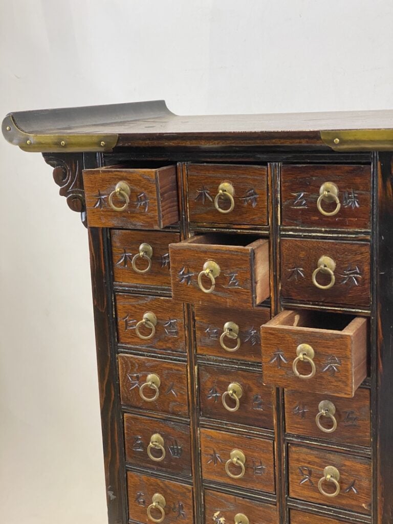 Petit meuble d'apothicaire à tiroirs peints de caractères chinois. Le fronton e…