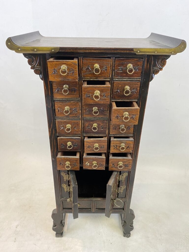 Petit meuble d'apothicaire à tiroirs peints de caractères chinois. Le fronton e…