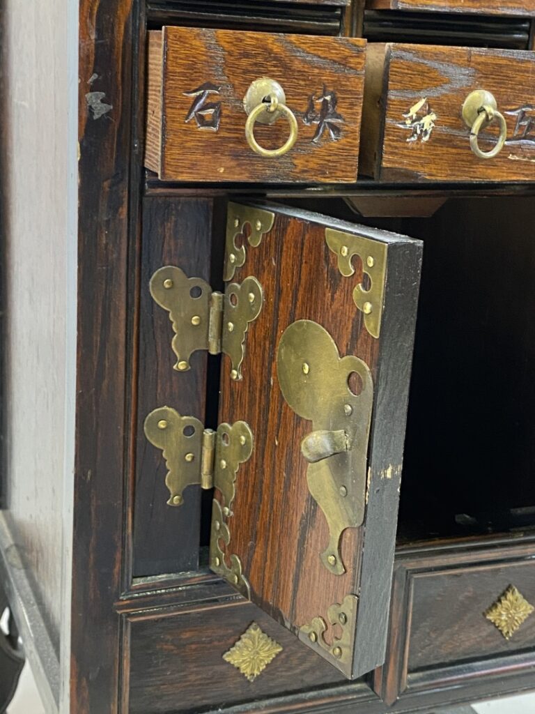 Petit meuble d'apothicaire à tiroirs peints de caractères chinois. Le fronton e…