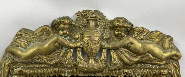 Petit miroir d'applique en bronze doré à deux lumières, le fronton orné de putt…