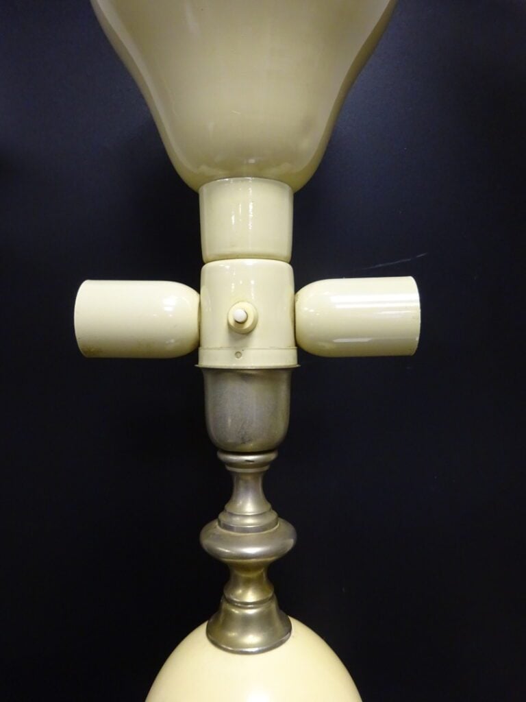 Pied de lampe en métal orné dans son fût d'un oeuf d'autruche, abat-jour en tôl…