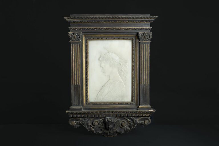 Plaque en albâtre sculptée en bas-relief d'un profil de jeune femme vêtue dans…