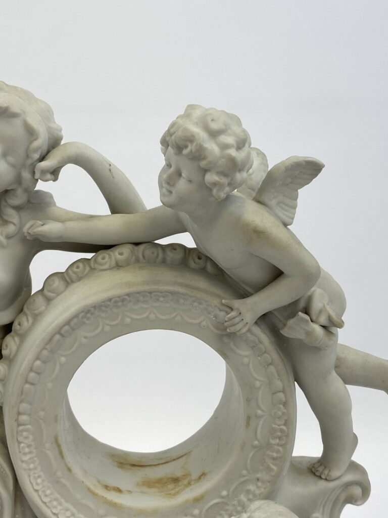 Porte montre en biscuit à décor d'angelots - (traces, manques) - 27 x 22 cm - R…