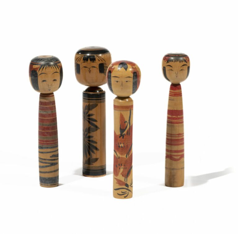 Quatre poupées kokeshi en bois peintes en rouge et noir de stries et de motifs…