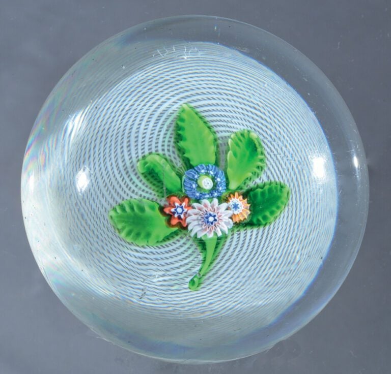 Saint-Louis. Presse-papiers à fond de latticino blanc spiralé orné d'un bouquet…