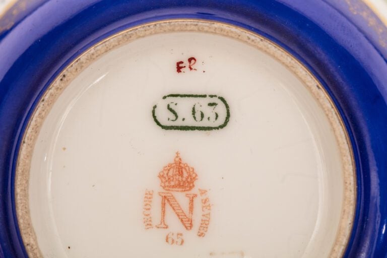 SEVRES - Paire de tasses et leurs sous-tasses munies d'anses guillochées, décor…