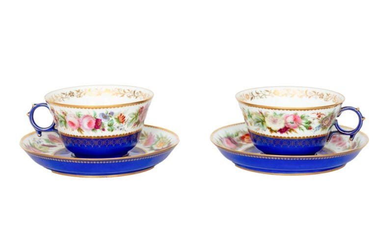 SEVRES - Paire de tasses et leurs sous-tasses munies d'anses guillochées, décor…