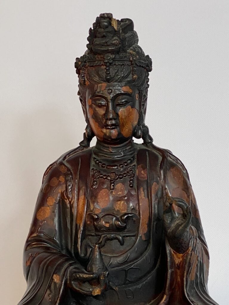 STATUE D'UNE DIVINITE EN BOIS LAQUE - XXe siècle - Assis sur un socle carré, el…