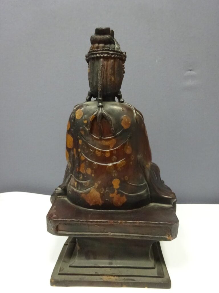 STATUE D'UNE DIVINITE EN BOIS LAQUE - XXe siècle - Assis sur un socle carré, el…