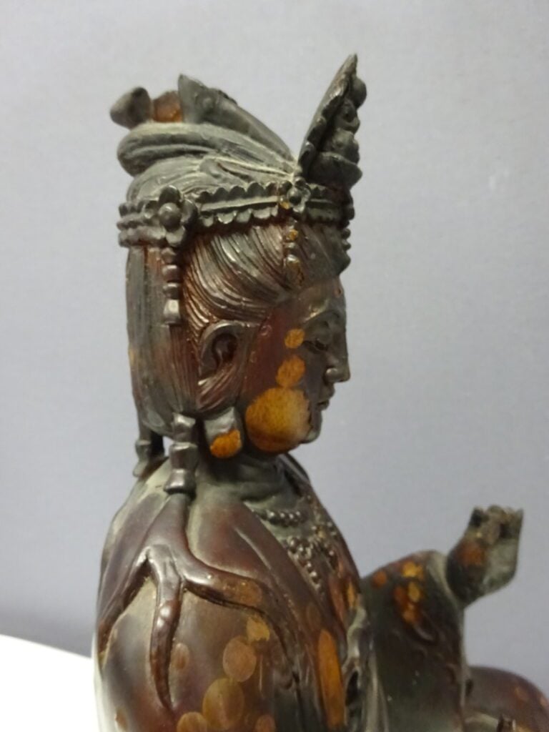 STATUE D'UNE DIVINITE EN BOIS LAQUE - XXe siècle - Assis sur un socle carré, el…
