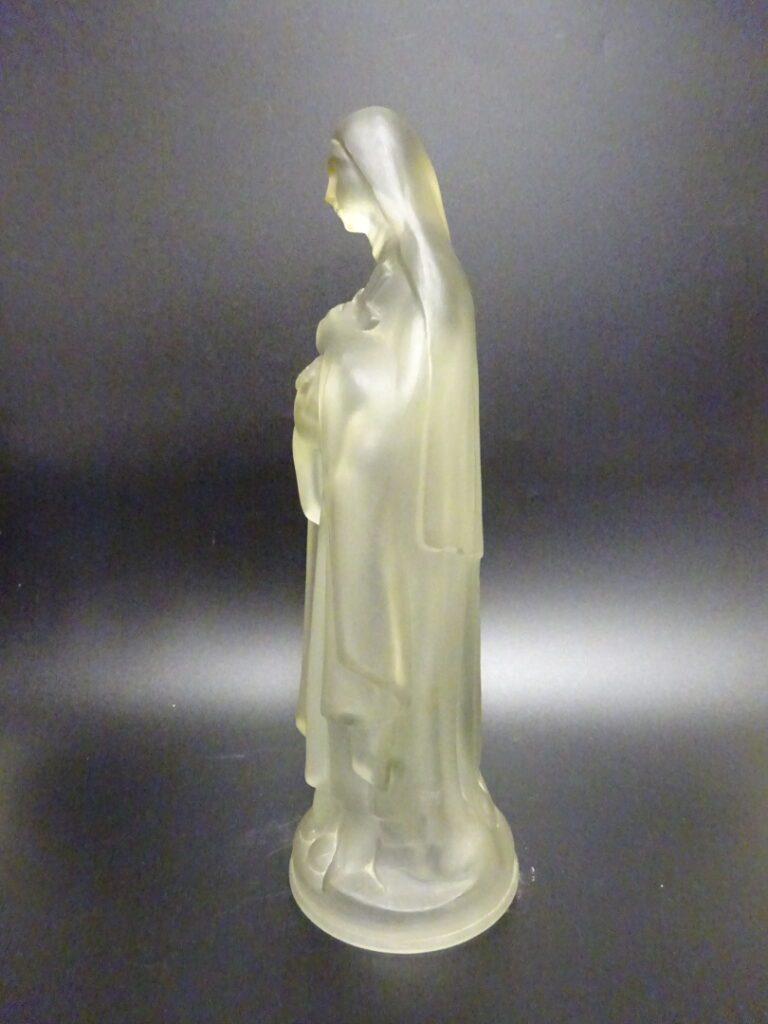 Statue en verre pressé moulé représentant une Vierge tenant une croix fleurie.…