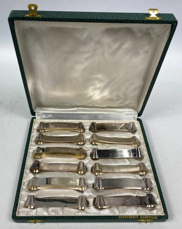 Suite de 12 porte-couteaux en métal argenté à décor d'une frise d'entrelacs - D…