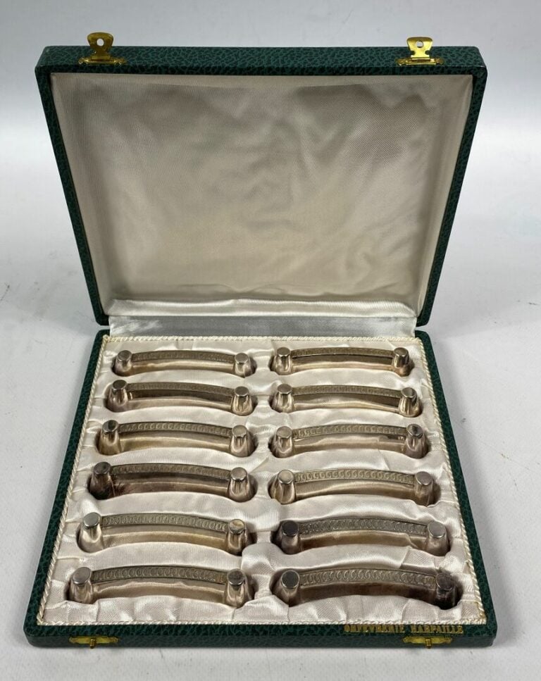 Suite de 12 porte-couteaux en métal argenté à décor d'une frise d'entrelacs - D…