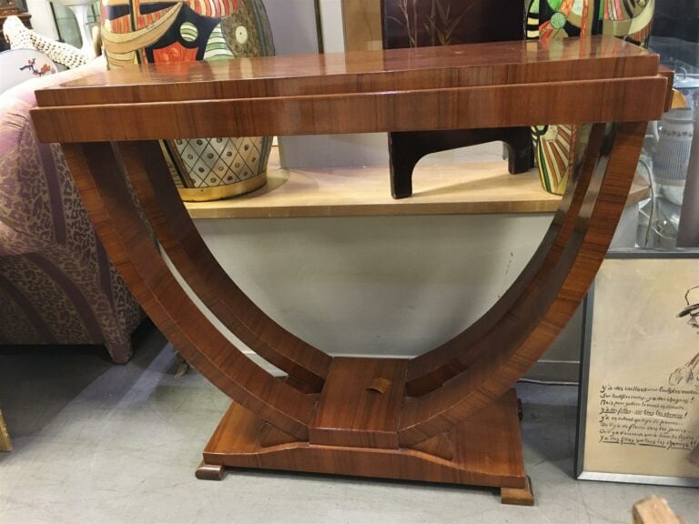 Table de milieu formant console en bois de placage, piètement en U. (sautes au…