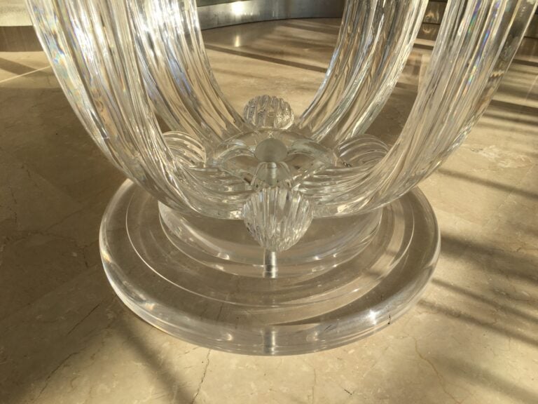Table de salle à manger en résine, le plateau en verre reposant sur un piétemen…