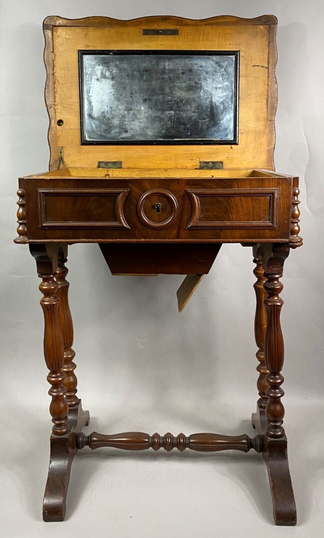 Table travailleuse en noyer ouvrant par un abattant découvrant un miroir et des…