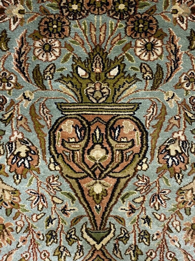 Tapis en laine à décor de vase fleuri et motifs stylisés sur fond bleu ciel, bo…