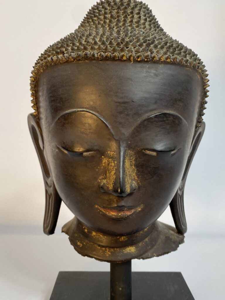 Tête de bouddha en bronze à patine brune et traces de laque or et polychromie r…