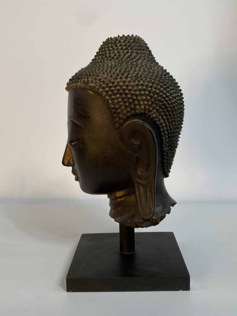 Tête de bouddha en bronze à patine brune et traces de laque or et polychromie r…