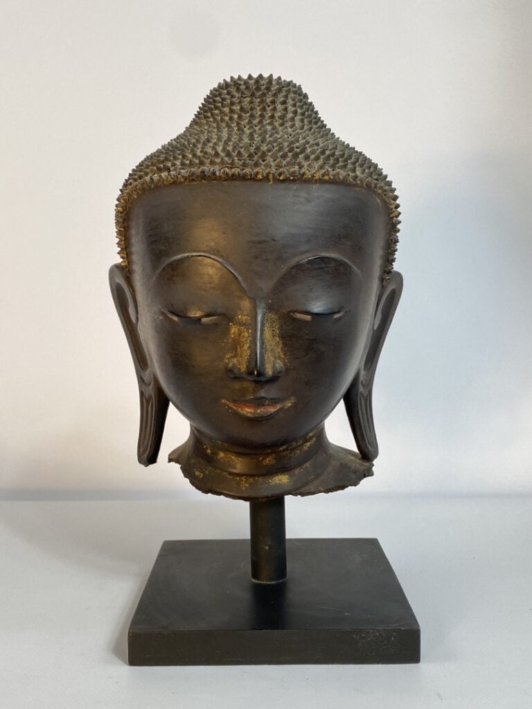 Tête de bouddha en bronze à patine brune et traces de laque or et polychromie r…