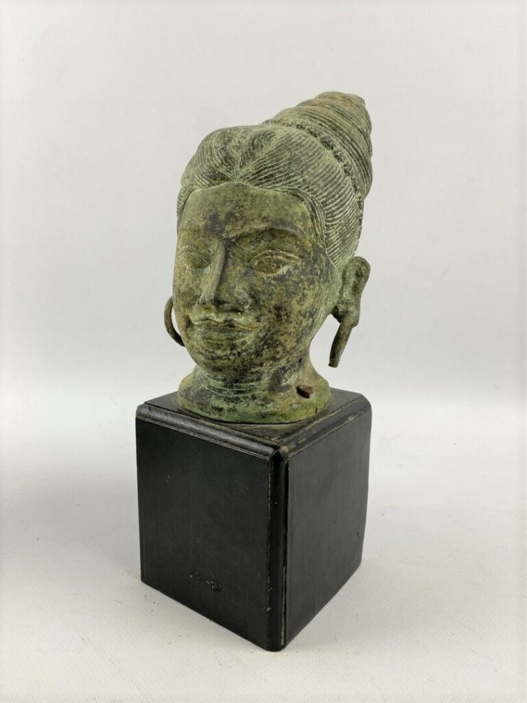 Tête de divinité en bronze sculpté à patine verte, légère trace de dorure - Asi…