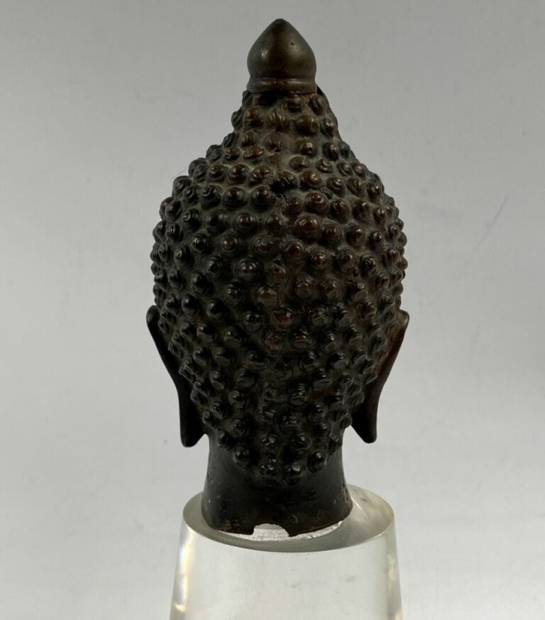 THAILANDE - Tête de bouddha en bronze. Le visage serein, il est représenté les…