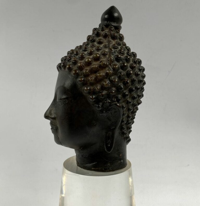 THAILANDE - Tête de bouddha en bronze. Le visage serein, il est représenté les…