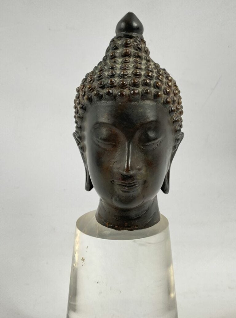 THAILANDE - Tête de bouddha en bronze. Le visage serein, il est représenté les…