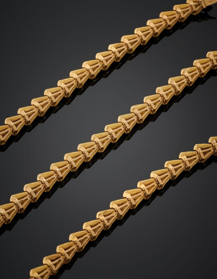 Trois BRACELETS articulés, en suite, en or jaune (750‰) ciselé et dépoli, à mot…