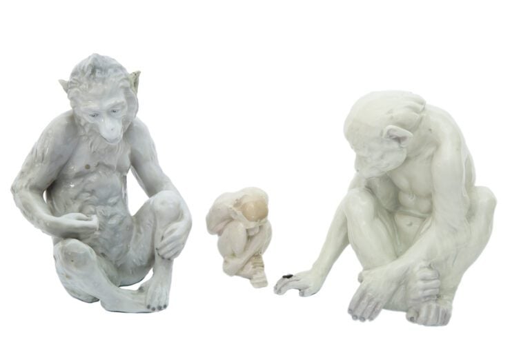 Trois statuettes en porcelaine émaillée représentant des singes assis (restaura…