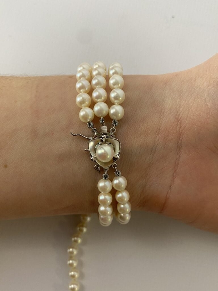 Un bracelet à trois rangs de perles, fermoir imitant l'or gris. - (un rang à re…