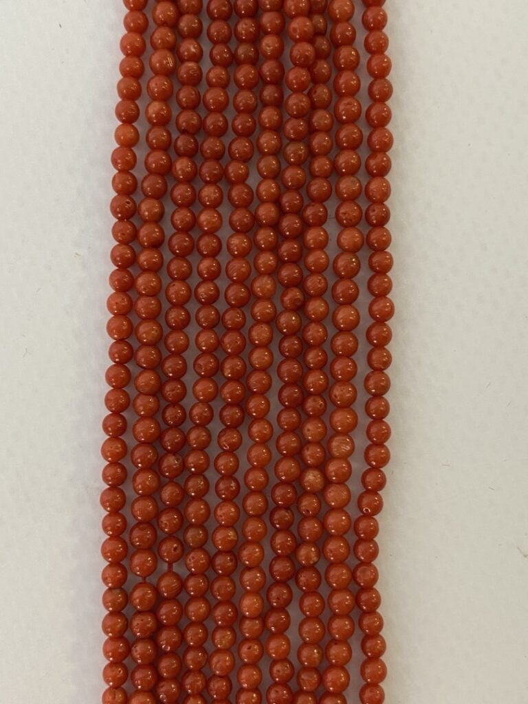 Un collier à cinq rang de perles miniatures en corail, fermoir en métal doré