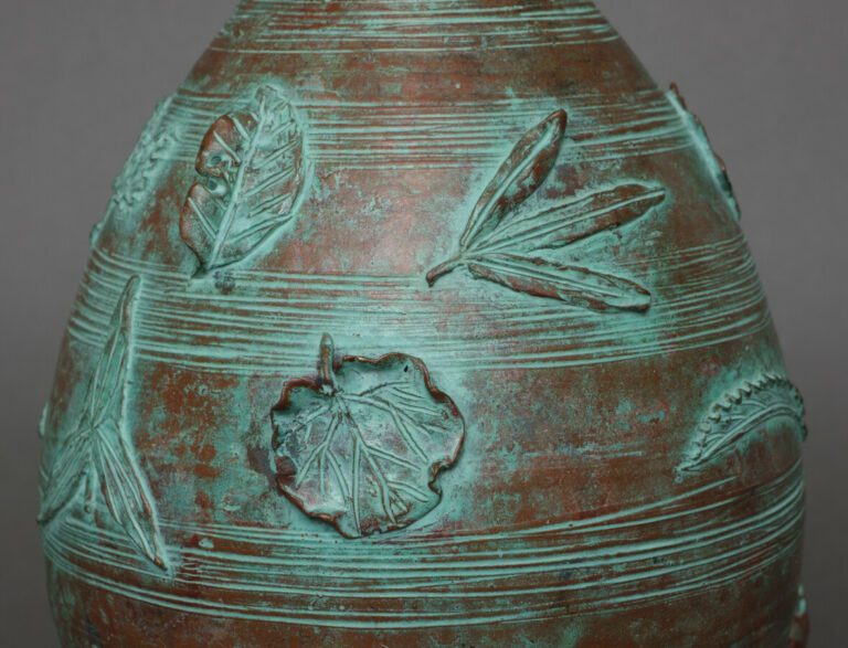 Vase en bronze ovoïde de taille moyenne avec un dessin continu en haut relief d…