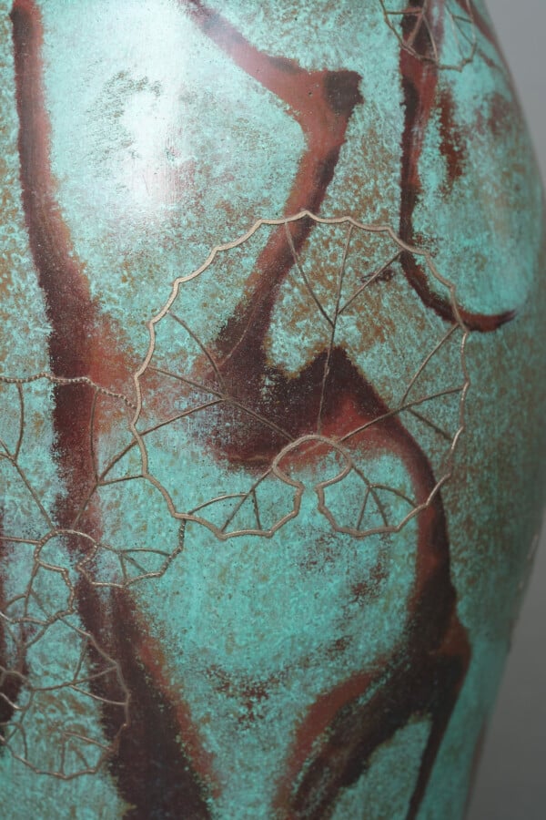 Vase en bronze patiné brun clair avec un col en forme de cône, un corps arrondi…