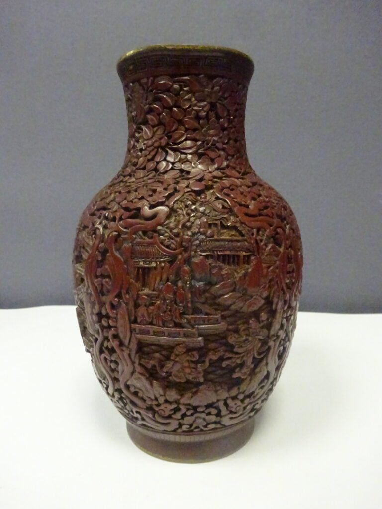 [-] VASE EN LAQUE DE CINABRE SCULPTE - Chine, - A décor couvrant de rinceaux fl…