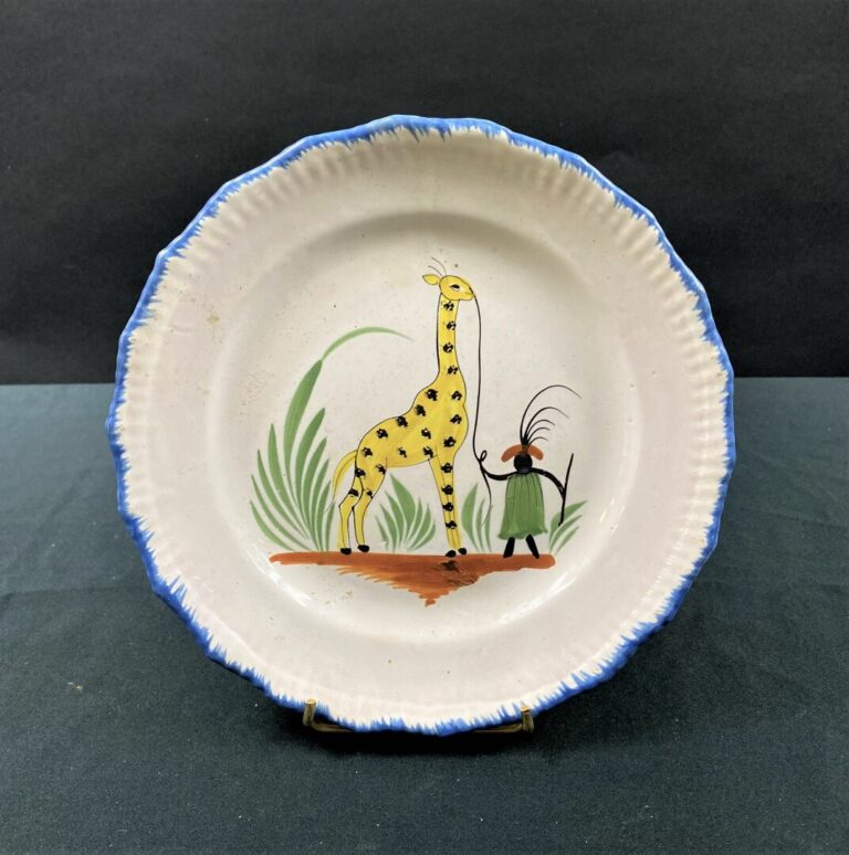 WALY - Assiette à bord contourné, décor polychrome d'une girafe tenue par son g…
