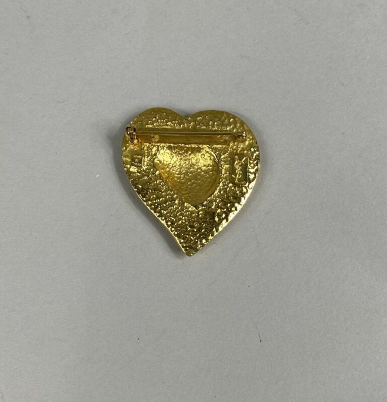 Yves SAINT LAURENT - Broche en métal doré figurant un coeur, inscription "Yves…