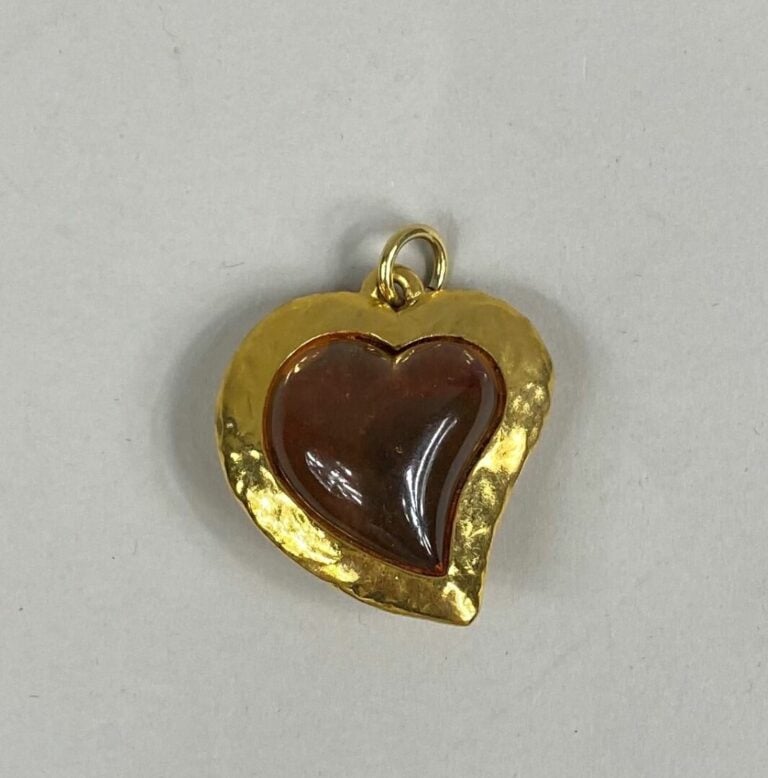 Yves SAINT LAURENT - Important pendentif en métal doré légèrement martelé figur…