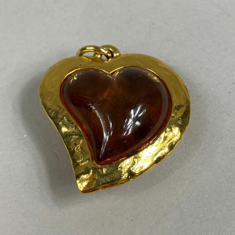 Yves SAINT LAURENT - Important pendentif en métal doré légèrement martelé figur…