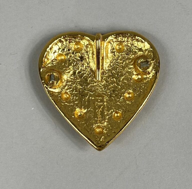 Yves SAINT LAURENT - Pendentif en métal doré figurant un coeur à motif de clous…