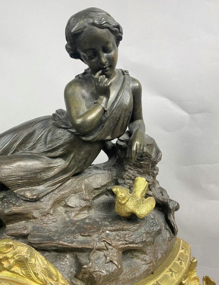 Pendule en bronze patiné et bronze ciselé doré figurant une jeune fille pensive…