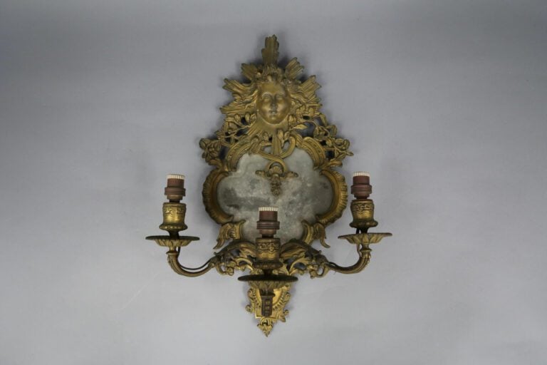 Miroir d'applique à trois lumières en bronze ciselé doré à décor de mascarons e…