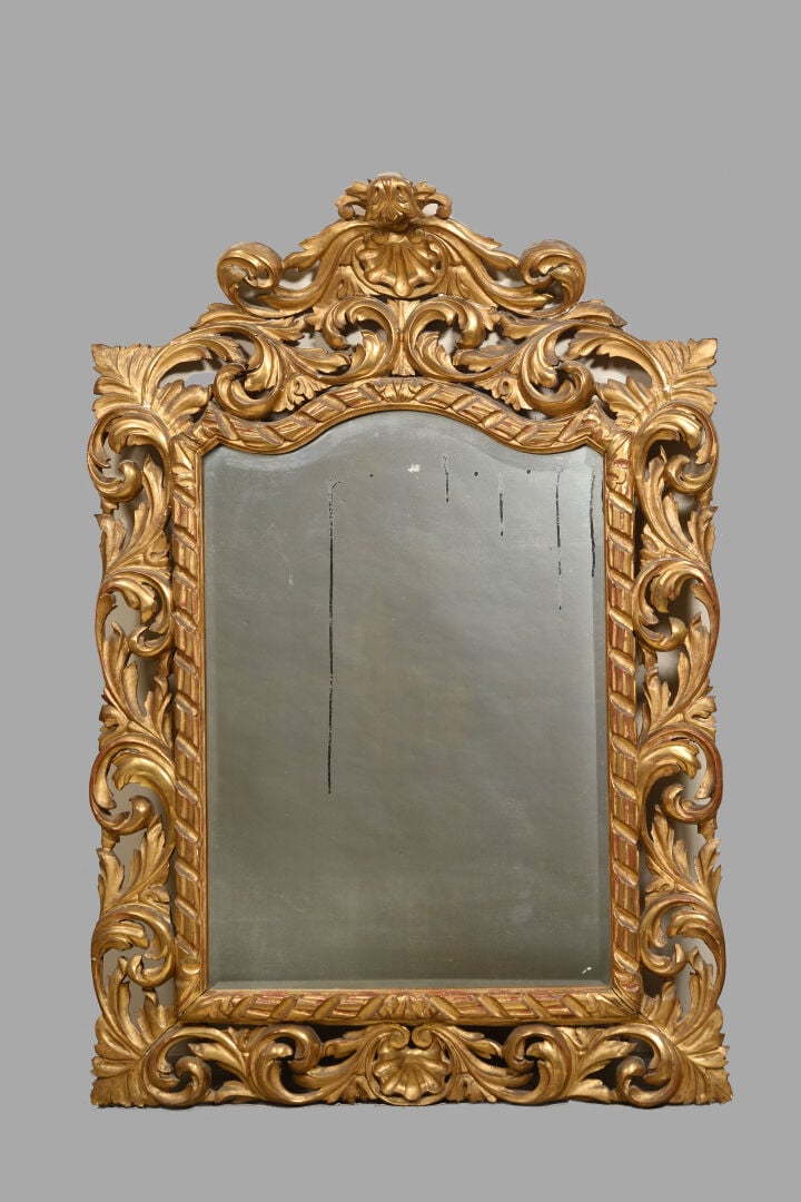 Important miroir en bois et stuc doré richement sculpté d'une frise rubanée, en…