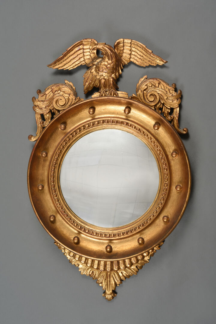 Miroir sorcière à encadrement en bois doré sculpté sommé d'un aigle aux ailes d…