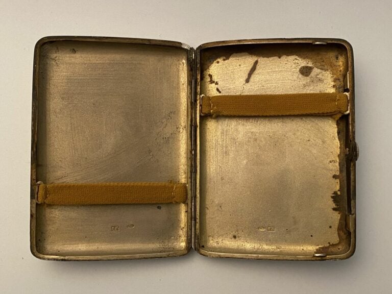 Etui à cigarette en argent 800 0/00 et vermeil. Le couvercle décoré à motif de…